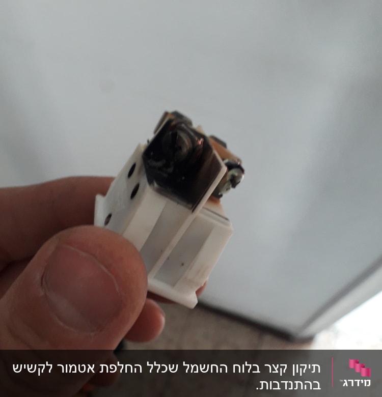 שקע חשמלי עם סימני שריפה ביד חשמלאי